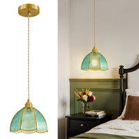 Blue glass pendant light shown with full hanging suspension and bedside installation scene