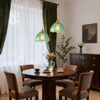 Blue textured glass pendant light with gold frame hanging above a dining table