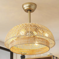 Lit gold rattan caged ceiling fan with light featuring a woven dome shade and warm illumination