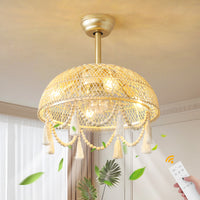 Decorative ceiling light fixture with tassels and a remote control in a room setting.