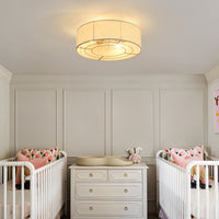 Gold linen-blend flush mount ceiling fan with light installed in a nursery