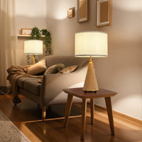 Farmhouse rattan-finish table lamps with beige linen shades lighting a warm living room beside a sofa