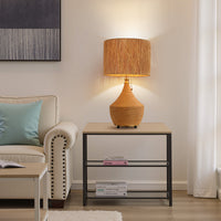 Boho rattan table lamp glowing on a side table beside a living room sofa