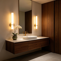 Gold LED wall sconce installed beside bathroom mirror