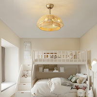 Gold boho rattan ceiling fan with light installed in a kids bedroom above a white bunk bed